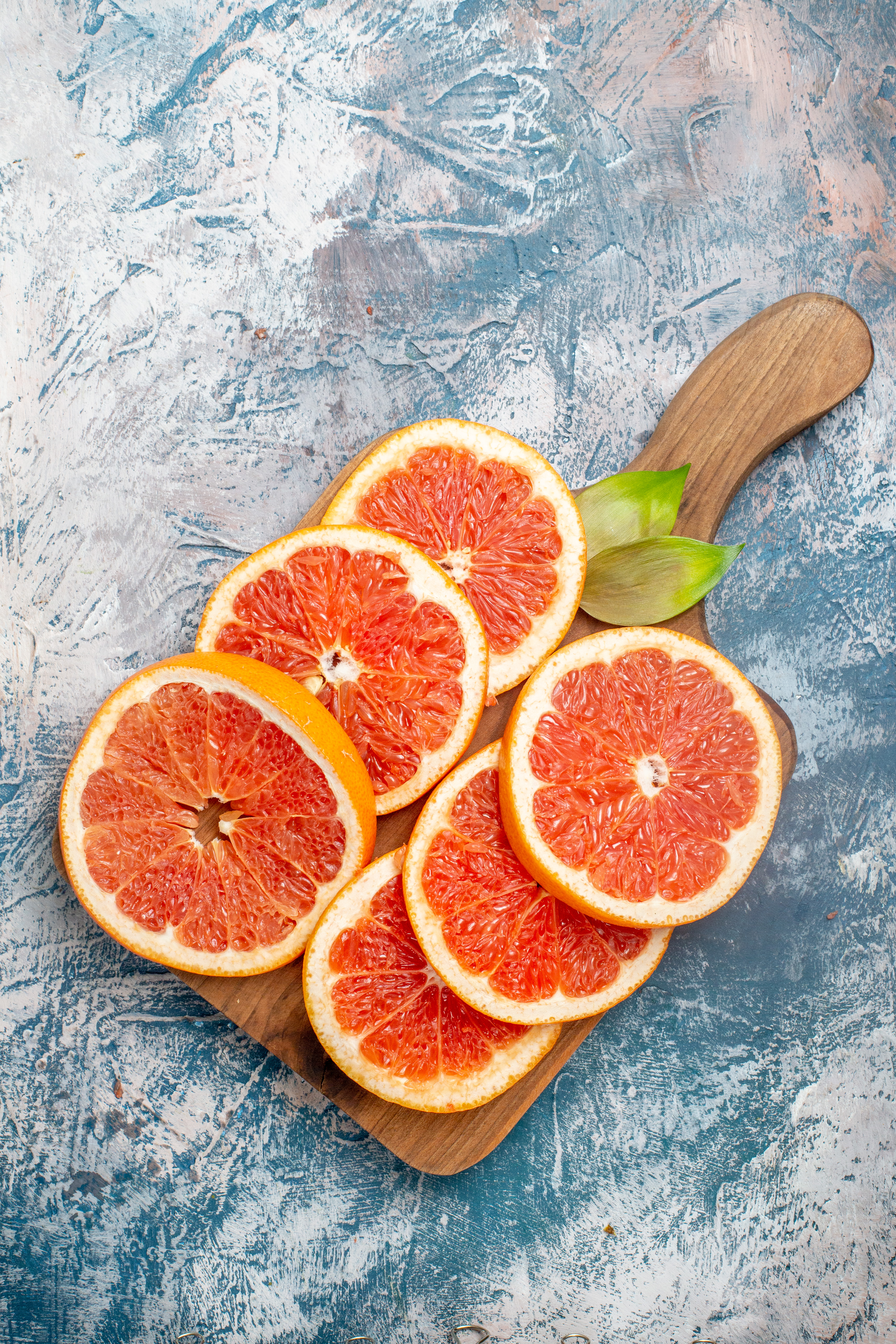 top-view-cut-grapefruits-cutting-board-blue-white-surface (1)